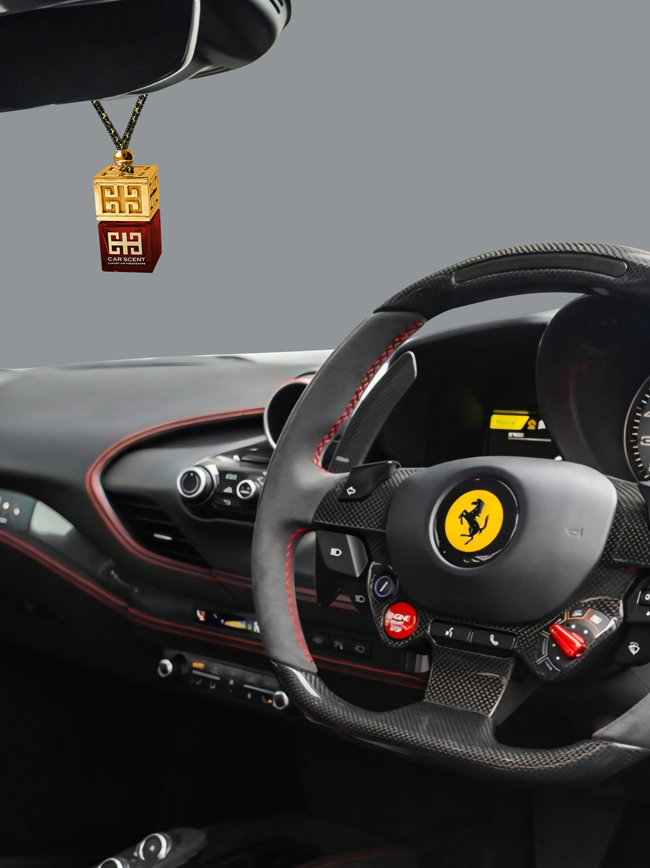 Steering wheel of a Ferrari with a pendant hanging from the rearview mirror on a gray background