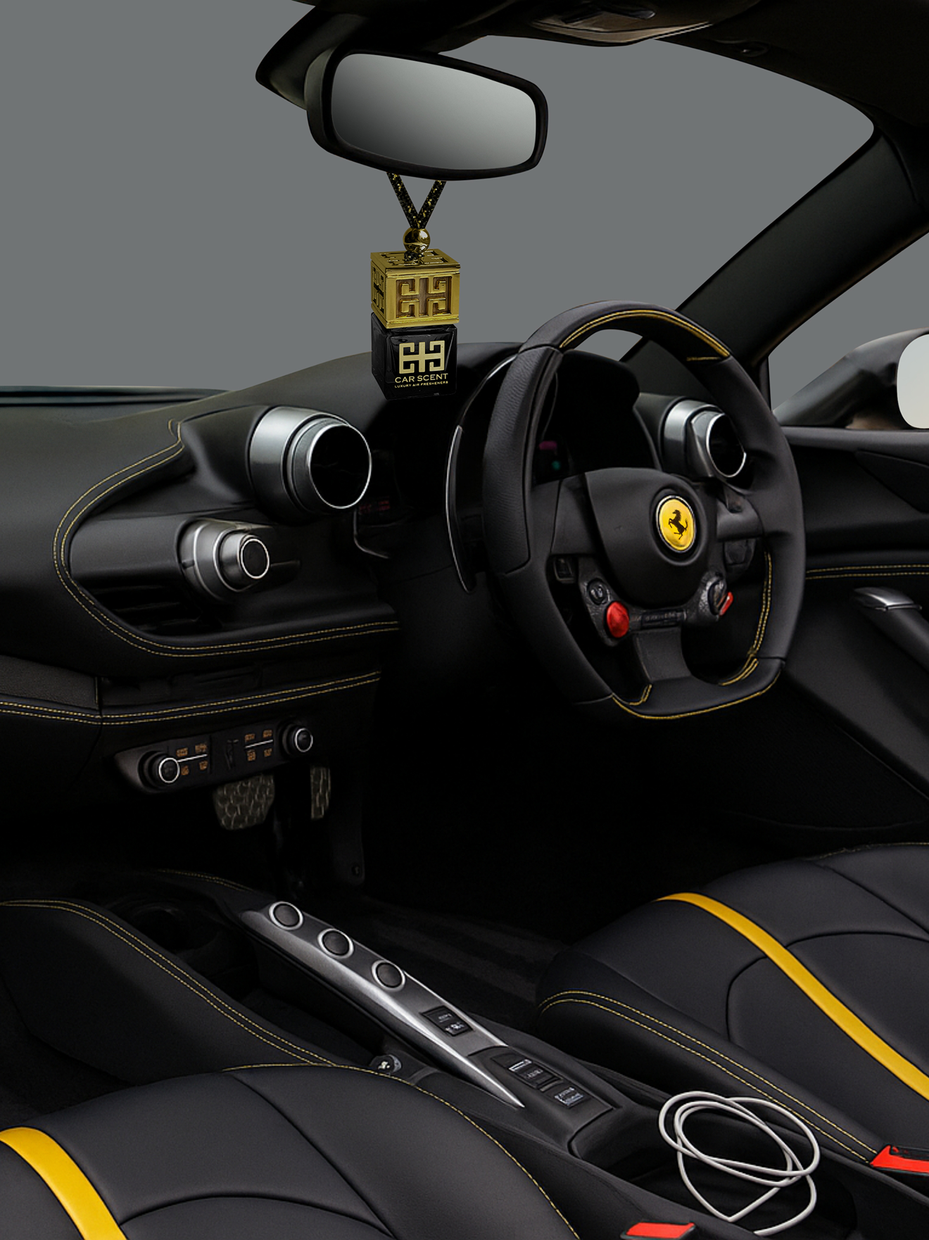 Car interior with a steering wheel emblem and a hanging decorative item.